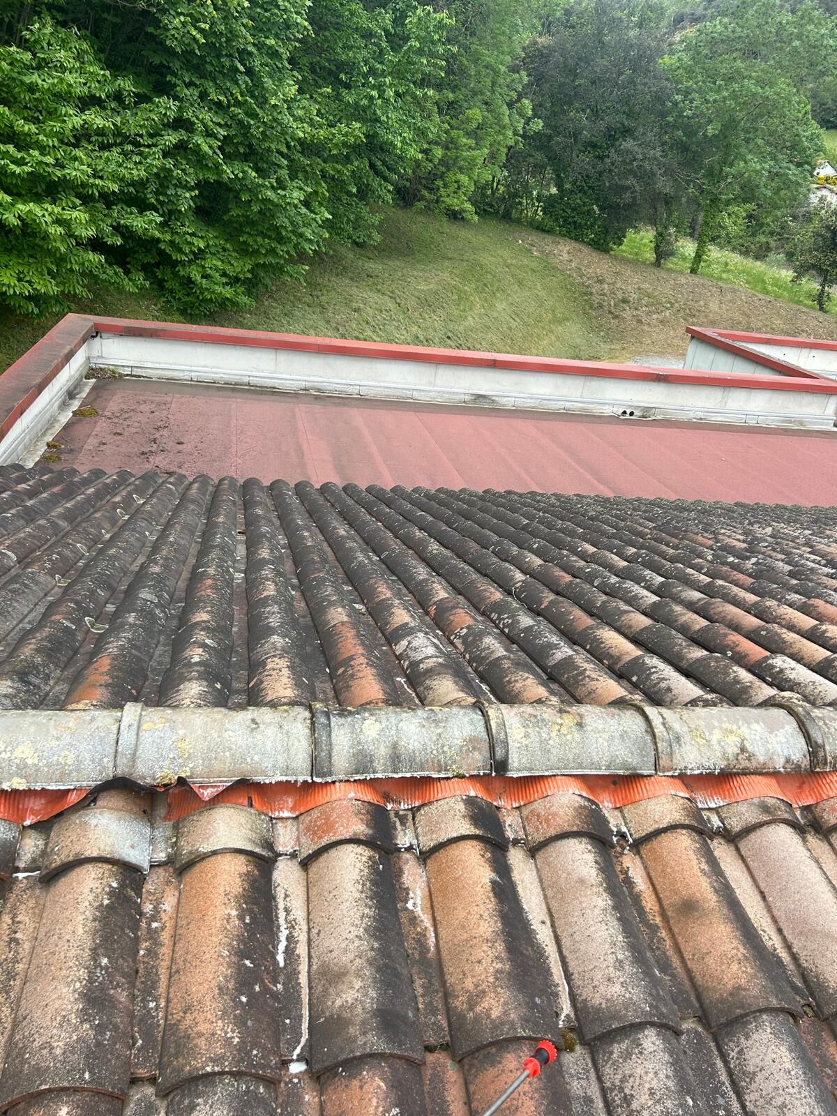 Faîtage et rangs de tuiles canal sur une toiture en cours de contrôle