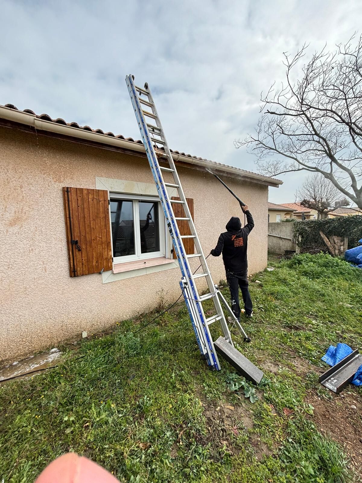 Intervention à l'échelle sur la gouttière d'une maison de plain-pied